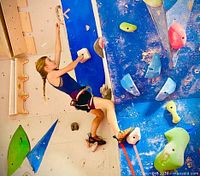 Child climbing bright blue indoor wall
