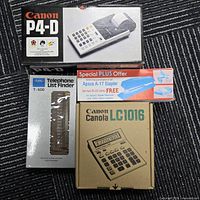 Boxed Canon P4-D calculator, Canon Canola LC1016 calculator, Apsco A-17 stapler, Carl T-500 telephone list finder