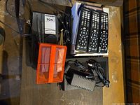 Lot overview showing receivers, remotes, power adapters, red boxes