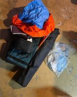 Bundle showing blue/orange folded gear, black chair bag, cooler bag, packaged mosquito net hat