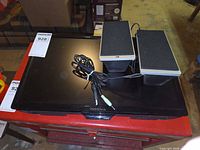 Front view of Insignia monitor with two UC-280 speakers and cables