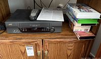 JVC HR-A5U VCR with remote, manual and stack of tapes including Shrek, Ice Age, Grinch