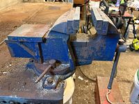 Side view of Mastercraft blue cast iron bench vise showing jaws, swivel base, handle and rust