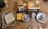 Overview of all items including boxed Philips coffeemaker, boxed MicroWare pour-over, yellow egg carriers, enamel bowl with utensils, stack of foil pans