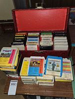Open case showing multiple rows of 8-track cartridges and additional stacks in front