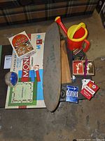 Group shot of all items on table including skateboard, watering can, board games, playing cards, PEZ dispensers, snow globe