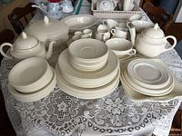 Full lot on table showing variety of plates, bowls, teapot, tureen, serving pieces