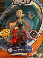 Close view of packaged Astro Boy figure showing accessory and trading card