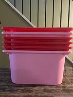 Side view showing stack of shallow red-pink bins seated in deep light-pink bin