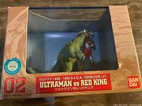 Front of boxed diorama showing figures through window and branding