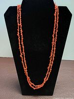 Necklace on black display, full length view