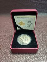 Coin in open case with certificate behind