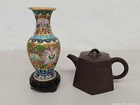 Front view of cloisonné vase on stand beside Yixing teapot