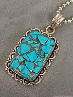 Front view of rectangular turquoise inlaid pendant on silver ball chain