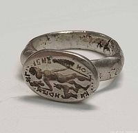 Front view showing bezel design with winged figure and lettering