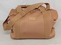 Full view of duffel front with shoulder strap and logo patch