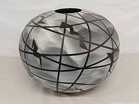 Full view of vase front showing abstract globe design and overall form