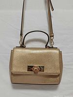 Front view of gold metallic Michael Kors Callie bag showing flap and clasp