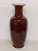 Full frontal view of tall oxblood porcelain vase showing overall shape and glossy glaze