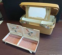 Samsonite train case beside open Farrington jewelry box showing interiors