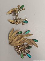 Brooch and earrings front view showing design and stones