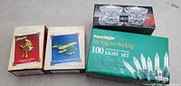 Front view showing four boxed items: two Hallmark ornaments, Mikasa crystal holders, 100-light set