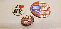 Front view of all three pinback buttons showing graphics and relative sizes