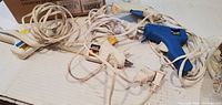four glue guns with cords spread out on surface