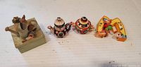 All four items lined: garden box, two miniature teapots, Elmo M figurine