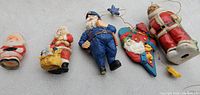Five ceramic Christmas ornaments laid out side by side