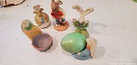 Five bunny figures and green egg overall view