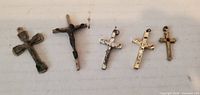 Front view of the five metal crucifix pendants