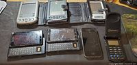 Overall lot showing PDAs, slide smartphones, iPhone, flip phone