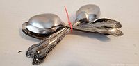 Assorted large spoons bundled with red zip tie, view of decorative handles and bowls