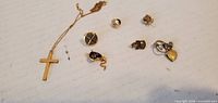 Overall lot view showing cross necklace and six small pinbacks/charms