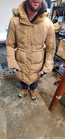 Front view of tan Bebe hooded coat worn by model