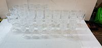 front view of all clear crystal stemmed glasses arranged in rows on white surface