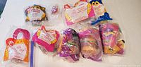 Overall group shot of eight sealed McDonald’s Happy Meal toys