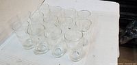 top angled view of 15 clear glass tumblers grouped on surface