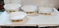 Four CorningWare Spice of Life casserole dishes and one glass lid displayed together