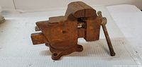 Left side view of Columbian bench vise showing swivel base and rusted red paint