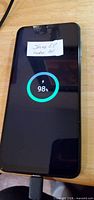 Front of smartphone powered on showing charging indicator