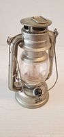 Front view of silver lantern showing globe and knob