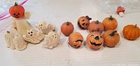 All figurines grouped; ghost with pumpkin head, four small ghosts, ten pumpkins