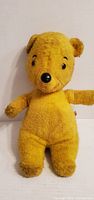 Front view of yellow Winnie the Pooh plush doll