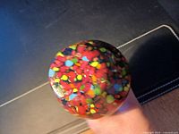 base showing multicolored splatter pattern and small chip