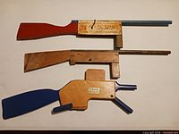 Three wooden tommy gun toys stacked
