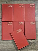 Front covers of six volumes with one laid on top showing title