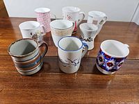 Front view of nine assorted mugs on table