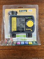 Front view of sealed Melnor AquaTimer showing LCD, buttons, yellow accents, model 45016, two hose connectors